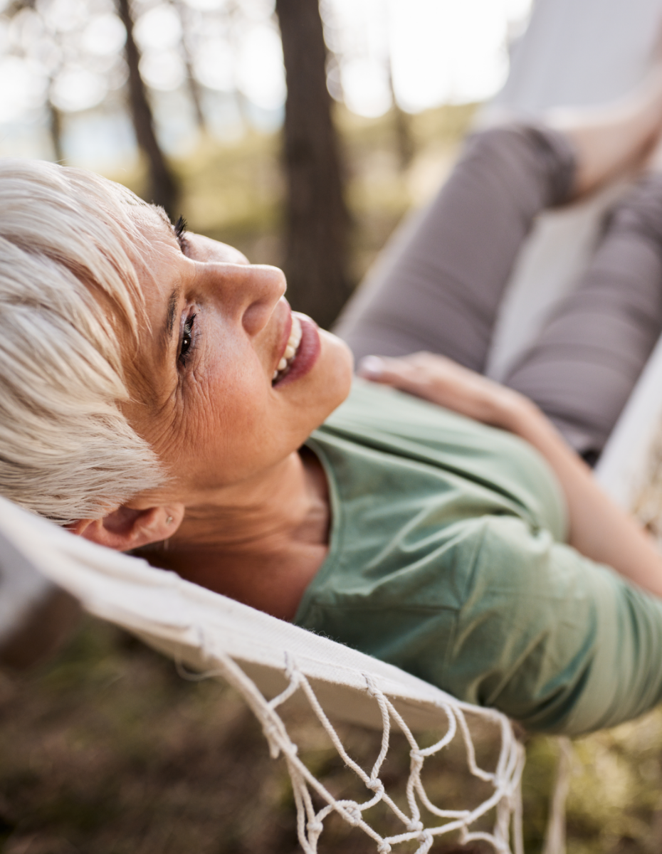 Frau liegt entspannt in Hängematte.